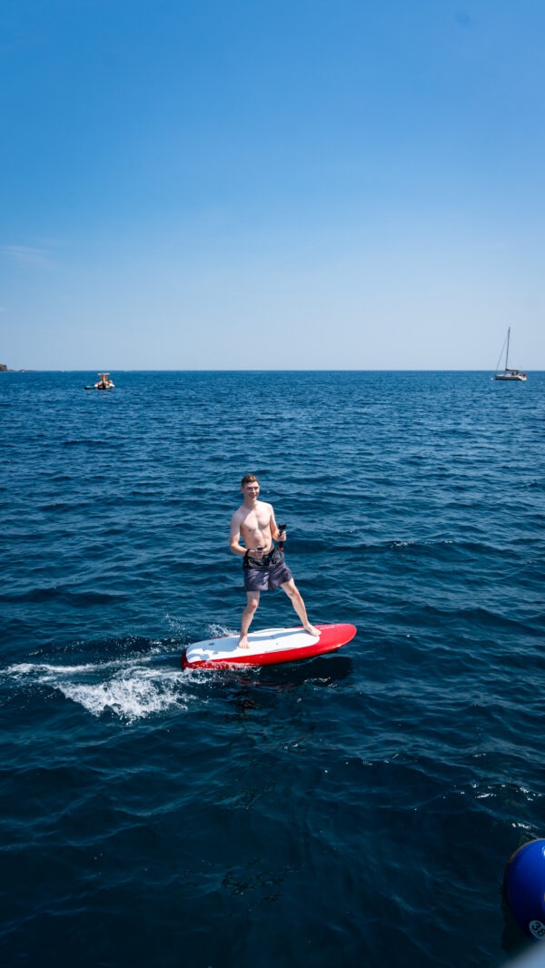 Mann beim E-Foil Surfen auf dem Meer als Aktivität einer Sportwagen Erlebnisreise.