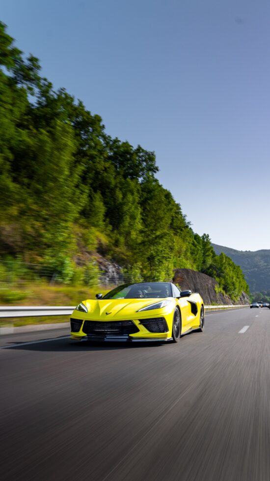 Gelbe Corvette C8 fährt dynamisch auf einer Experten-Tour durch die Berge.